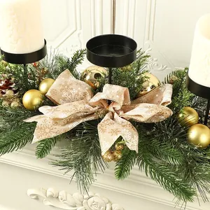 Close-up of Christmas candle holder centerpiece with pine branches and rustic bow