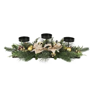 Detailed view of a Christmas candle holder centerpiece with three cups and decorations