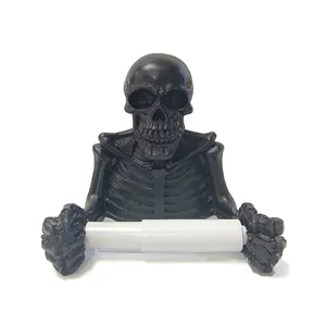 Close-up of a black resin skeleton toilet paper holder with a white plastic roller.