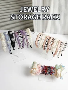 Clear acrylic headband and jewelry organizer stands displaying various accessories