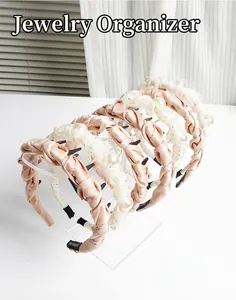 Clear acrylic headband display stand organizing multiple fabric hairbands and accessories