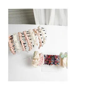 Transparent acrylic headband display stand showing various hair accessories and scrunchies