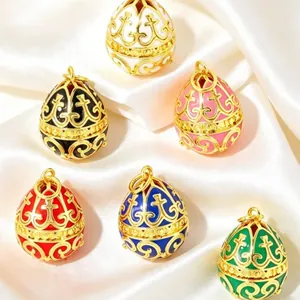Close-up of colorful Fabergé-style enamel egg pendants with gold filigree on satin.