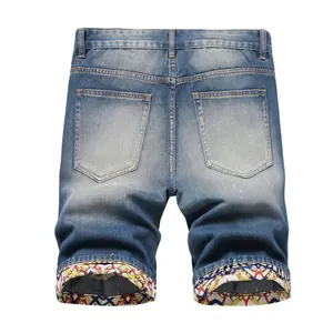 Fashionable men's blue denim shorts featuring unique colorful printed rolled-up cuffs back view