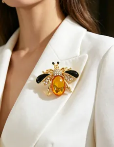 Detail view of an elegant honey bee brooch pinned on a white blazer lapel.