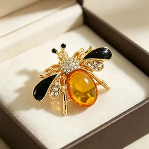 Macro detail of a golden honeybee brooch featuring amber stone and sparkling rhinestones