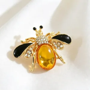 Detailed close-up view of elegant bumblebee brooch with amber resin and clear rhinestones.