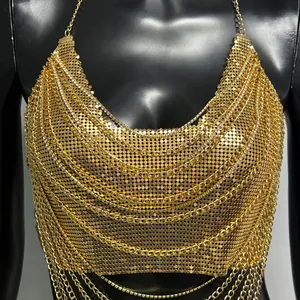 Détail du haut dos nu en paillettes dorées avec plusieurs chaînes de strass pour festival