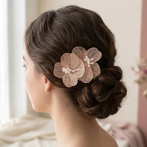Close-up detail of pink wire flower hair comb with pearls on a bridal bun hairstyle.