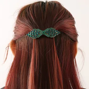 Back view of elegant emerald green crystal rhinestone spring hair clip on brown hair