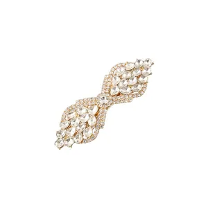 Detailed view of an elegant gold bow-shaped hair clip encrusted with clear pear crystals