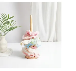 Close-up detail of a minimalist solid wood scrunchie stand holding colorful hair ties.