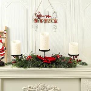 Detailed view of Christmas centerpiece with candles, red bow, and pine needles
