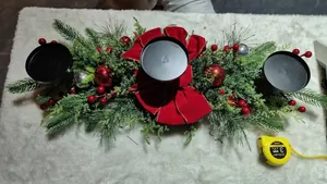 Detailed view of Christmas centerpiece with pine needles, red bow, and candle holders