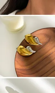 Détail en gros plan de boucles d'oreilles modernes bicolores or et argent en goutte