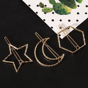 Detail of gold geometric hair clips with twisted texture in moon, star and hexagon shapes