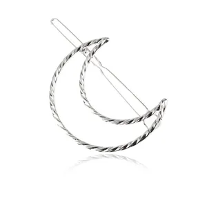 Detailed view of silver twisted crescent moon hair clip with textured metallic finish