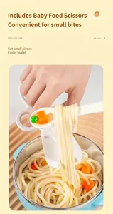Close-up of white baby food scissors cutting noodles in a blue stainless steel bowl