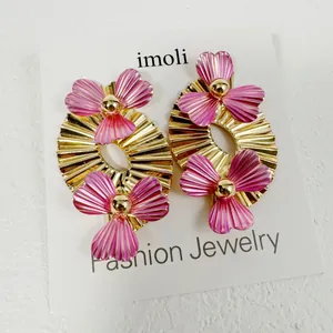 Vue détaillée de boucles d'oreilles rétro en feuilles d'éventail dorées avec fleurs.