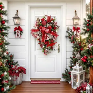 Festive red and white candy cane Christmas teardrop wreath hanging on a white front door