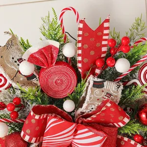 Detail of Christmas candy wreath decoration with red ribbons and festive ornaments