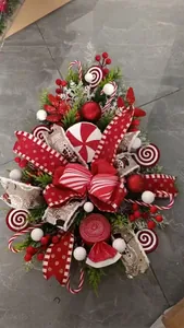 Close-up of a festive candy Christmas teardrop swag with red bows and peppermint ornaments