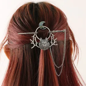 Close-up detail of a vintage silver hair stick featuring wolf and moon motifs on hair