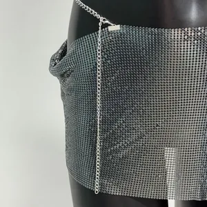Detailansicht eines silbernen Minirocks mit Pailletten und Kettendetails für Clubwear.