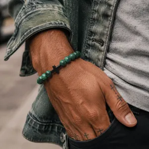 Close-up of a men's 8mm green malachite bead bracelet with a black cross charm