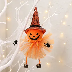 Detailed view of Halloween pumpkin witch hanging ornament with orange tutu and bells.