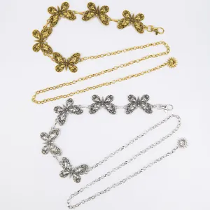 Detail of Bohemian style butterfly waist chains in gold and silver metal finish