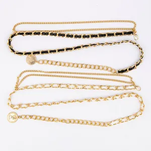 Detail view of retro gold waist chain belts with black and white leather interlacing.