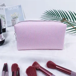 Detail shot of pink seersucker striped travel cosmetic bag in a lifestyle setting context