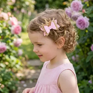 Detailed view of a girl wearing a pink glittery crown bow hair clip in a rose garden.