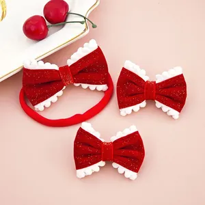 Detail view of red velvet hair bows with white pom-poms and gold glitter accents
