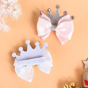 Detailed view of pink and white crown bow hair clips for kids with glitter and rhinestones.