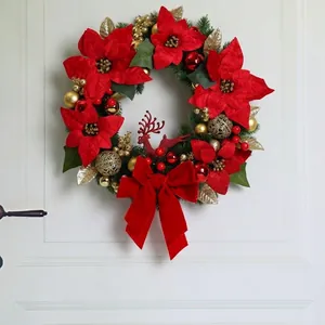 Detailed view of Christmas wreath featuring red poinsettia and festive gold ornaments