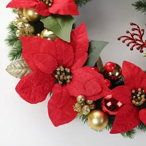 Close-up of a festive Christmas wreath with red poinsettias and gold ornaments