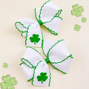 Dettaglio di fiocchi per capelli bianchi con stampa trifoglio verde per San Patrizio