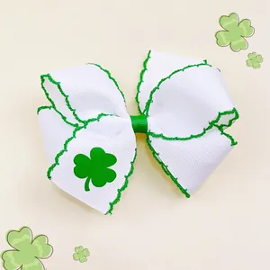 Dettaglio di un fermaglio per capelli a fiocco bianco con trifoglio per San Patrizio