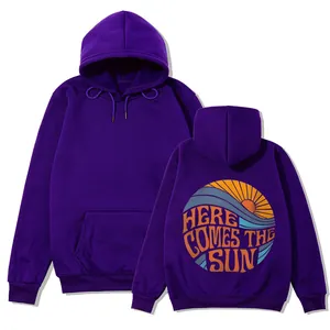 Sweat à capuche violet oversize avec un imprimé 'Here Comes the Sun' graphique au dos.
