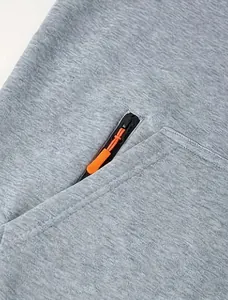 Detail shot of grey fleece hoodie showing zipper with orange puller and fabric texture
