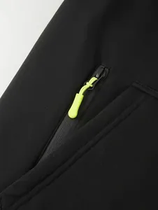 Detailed close-up shot of a lime green zipper puller on a sleek black men's hoodie.