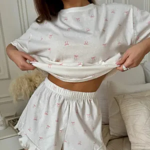 Vue détaillée d'un ensemble de pyjama blanc pour femme avec un imprimé nœud rose