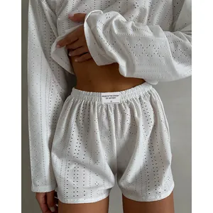 Vue détaillée d'un ensemble de pyjama blanc ajouré avec haut à manches longues et short