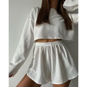 Détail d'un ensemble de pyjama blanc ajouré deux pièces avec haut à manches longues