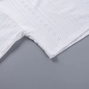 Gros plan détaillé montrant le tissu brodé ajouré blanc d'un ensemble de pyjama décontracté