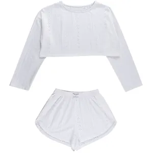 Gros plan d'un ensemble de pyjama blanc ajouré avec haut court et short assorti.