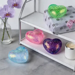 Macro detail shot of glitter heart-shaped squeeze toys in various colors on a shelf.