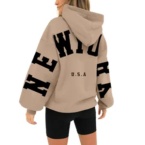 Back view of beige oversized hoodie featuring black 'New York' letter print detail